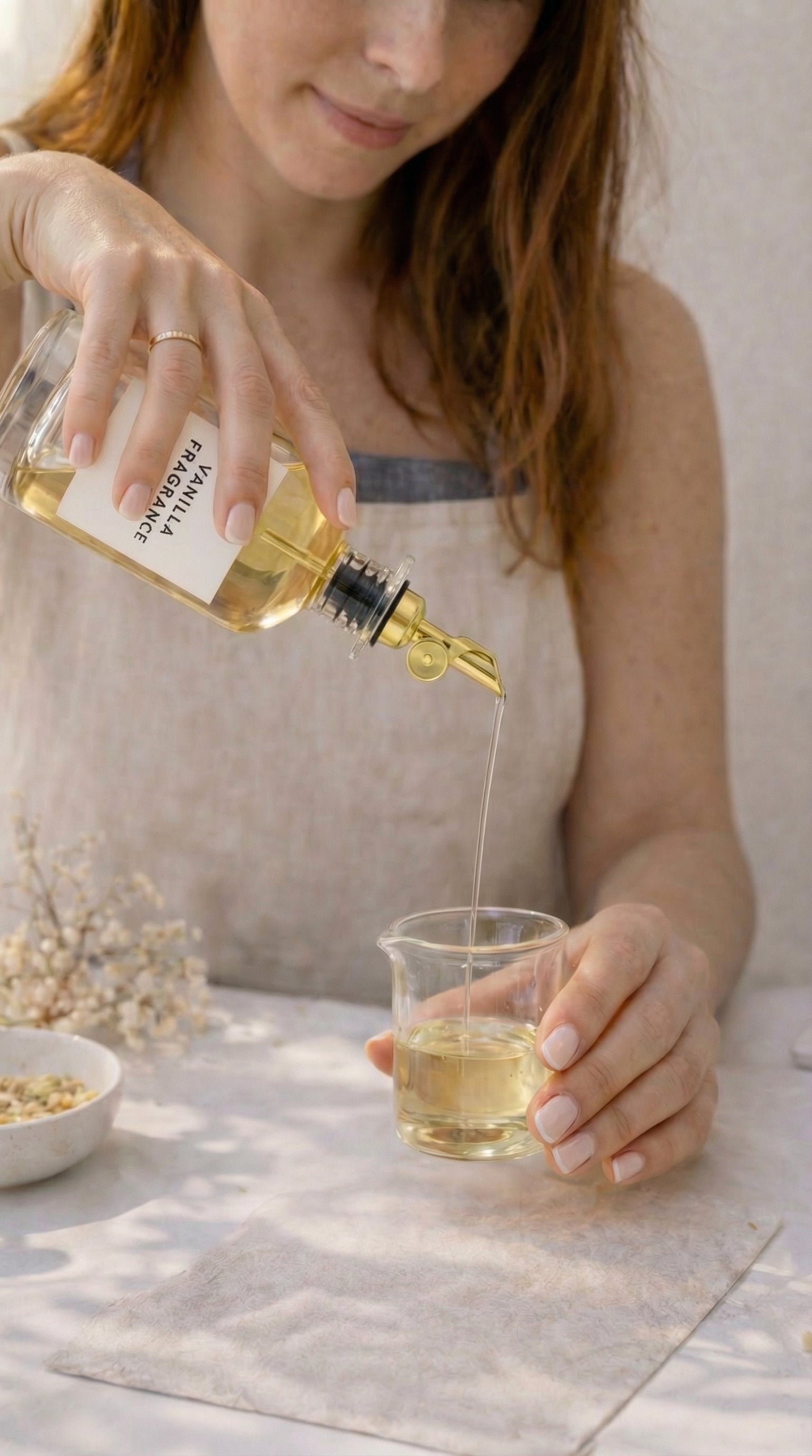 Adding fragrance oil to container during a candle making experience in Orlando.