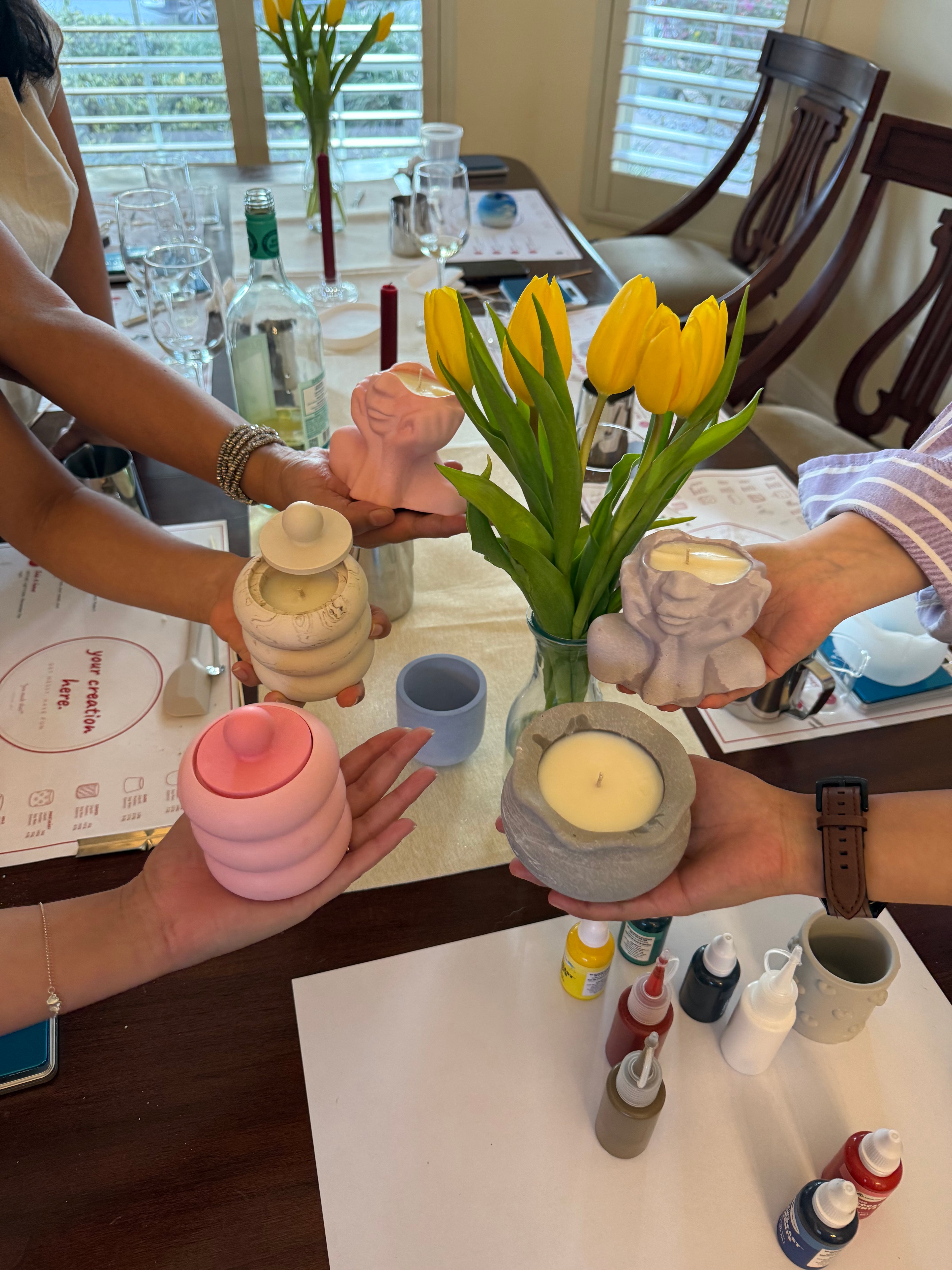 Guests holding their finished handmade candles created during a Set & Melt candle making experience.